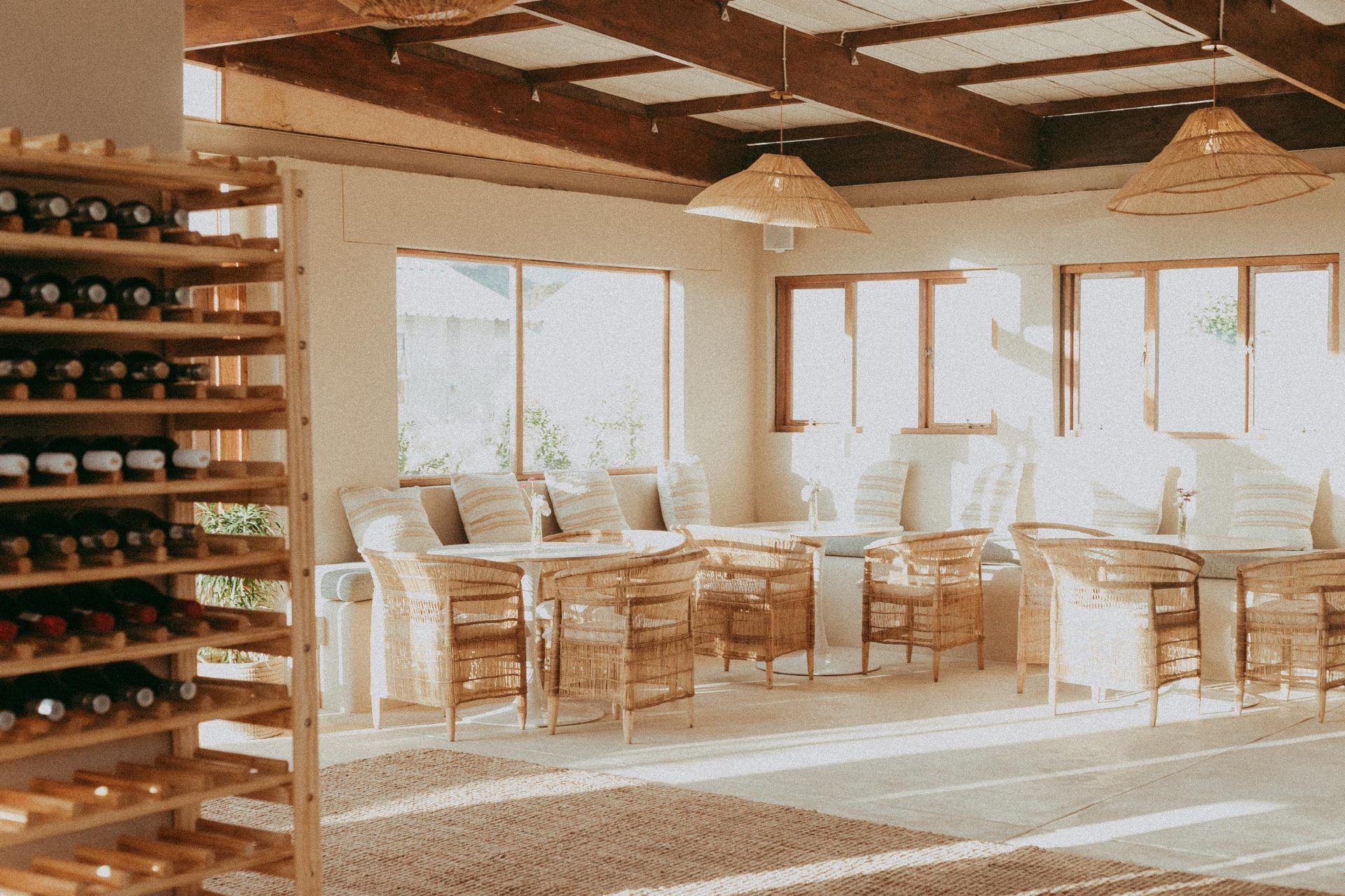 Sunlit Guten Morgen dining room with rattan chairs, woven pendant lights and a wine rack
